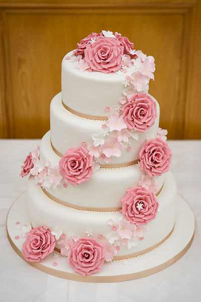 Four Tier Wedding Cake with Champagne Satin Ribbon and a Spiral of Handcrafted Blush Sugar Roses & Flowers.